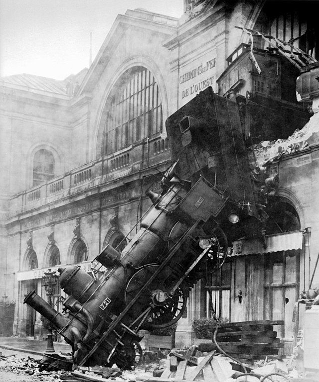 <a href="https://commons.wikimedia.org/wiki/File:Train_wreck_at_Montparnasse_1895.jpg">Photo credited to the firm Levy & fils by this site. (It is credited to a photographer "Kuhn" by another publisher [1].)</a>, Public domain, via Wikimedia Commons